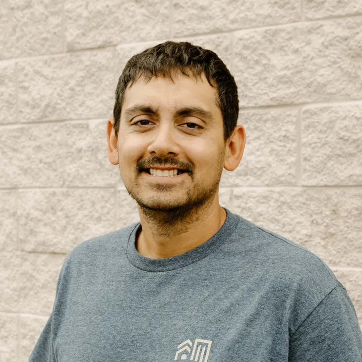Jason S., Senior Job Supervisor at GCM Construction, wearing a collared shirt in front of a concrete block wall.