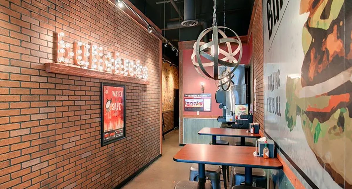 Interior of the My Burger restaurant featuring a stylish dining area with warm wood accents, pendant lighting, and a modern industrial aesthetic.