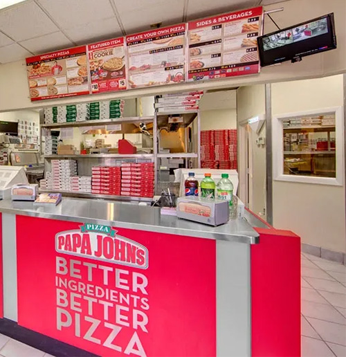 Customer service counter at the Papa John’s restaurant in Maple Grove, Minnesota, featuring branding, menu displays, and a functional food-service area completed by GCM Construction.