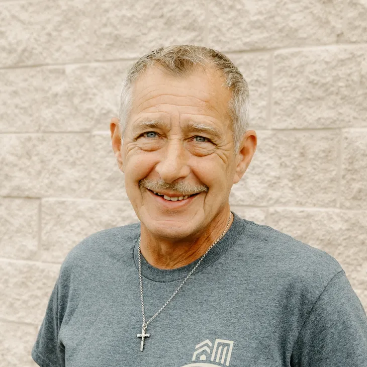 Rich H., Service Manager at GCM Construction, wearing a collared shirt in front of a concrete block wall.