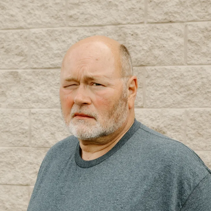 Steve F., Senior Service Technician at GCM Construction, wearing a collared shirt in front of a concrete block wall.